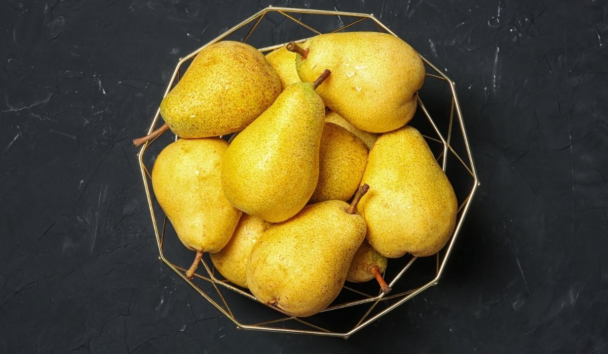 A Basket with fresh ripe pears on dark background