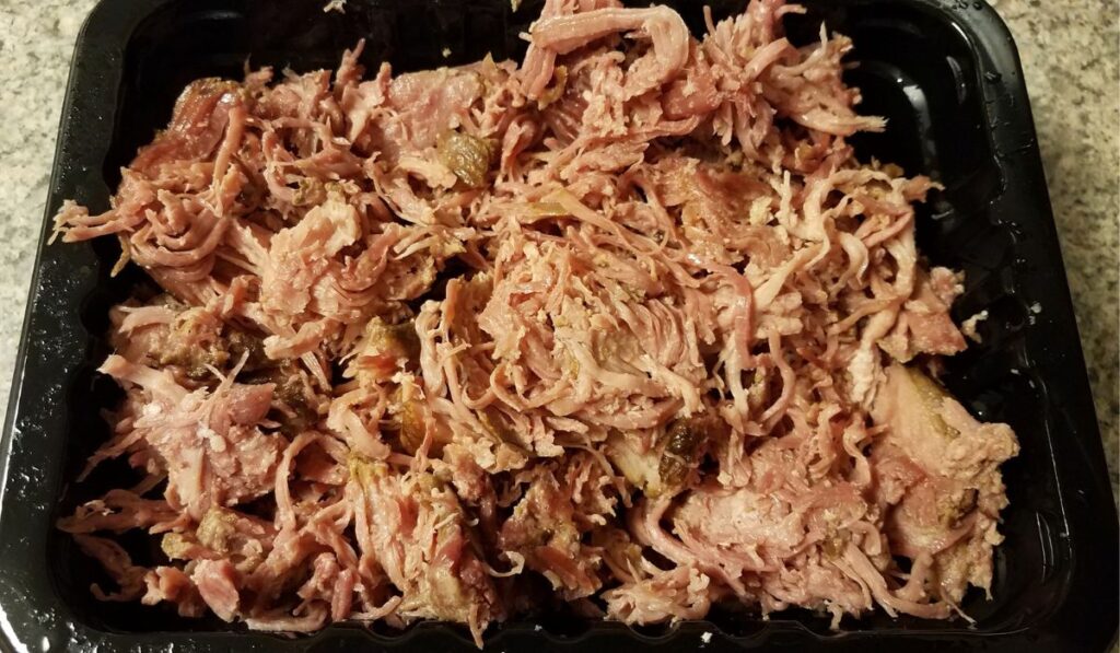 pile of pulled pork meat in plastic container